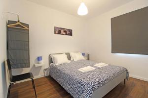 Schlafzimmer mit einem Bett mit einer schwarzen und weißen Bettdecke in der Unterkunft Laranjal Guesthouse in Vila do Conde