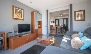 a living room with a couch and a tv at R138 Casa Jessy con gran jardin, piscina y AC in Calafell