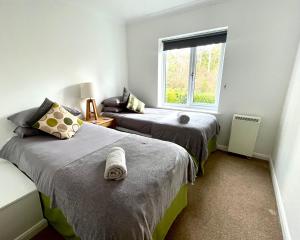a bedroom with two beds and a window at Haytor Court, Haytor, Dartmoor in Haytor