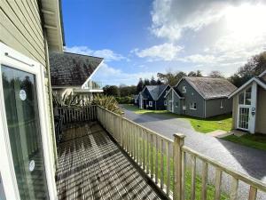 einen Balkon eines Hauses mit einem Zaun in der Unterkunft Trewhiddle Villa 29 in St Austell