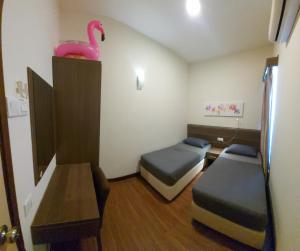 a room with two beds and a pink swan on the wall at GWE Homestay in Bayou Lagoon Waterpark Resort Melaka in Malacca