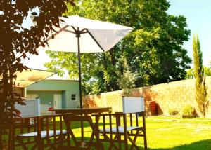 een tafel en stoelen met een parasol in de tuin bij Vina in Villa Elisa