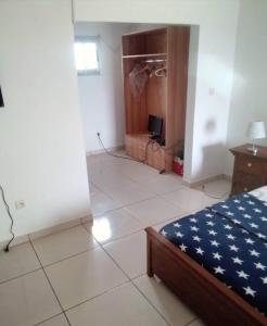 a bedroom with a bed and a tiled floor at Lovely 1-Bed duplex house in Abidjan