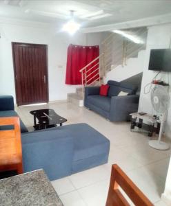 a living room with a blue couch and a table at Lovely 1-Bed duplex house in Abidjan