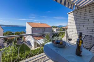 a balcony with a table and a bottle of wine at Studio Apartment in Crikvenica II in Dramalj