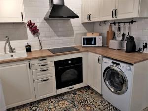 een keuken met een wasmachine en een wasmachine bij Casa Manuela Más que una Casa un Hogar in Toledo