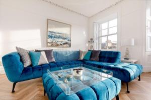 - un canapé bleu et une table basse dans le salon dans l'établissement Heart of Edinburgh City Centre 3 Bed Georgian Apt, à Édimbourg