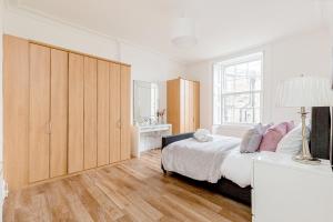 - une chambre avec un lit et une grande armoire en bois dans l'établissement Heart of Edinburgh City Centre 3 Bed Georgian Apt, à Édimbourg
