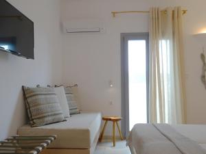 a white room with a bed and a window at Paros Bay in Parasporos