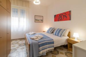 een slaapkamer met een bed met blauwe en witte lakens bij Villetta Kennedy in Ispica