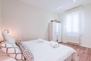 a bedroom with a white bed with pillows on it at MyHouseSpain - Estrena apartamento en el centro de Madrid - Atocha in Madrid