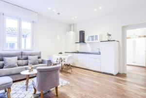 a living room with a couch and a table and a kitchen at MyHouseSpain - Estrena apartamento en el centro de Madrid - Atocha in Madrid