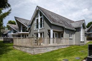 a house with a wooden fence in the yard at Trewhiddle Retreat V27 by Together Travel - Luxury 3-Bedroom Villa in St Austell
