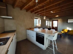 a kitchen with a counter and a table and chairs at Nachtegael Hoekhuis, knusse woning met prachtig vergezicht in Kluisbergen