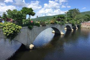 een brug over een rivier met mensen die erop lopen bij Blooming Inn Shelburne Falls in Shelburne Falls