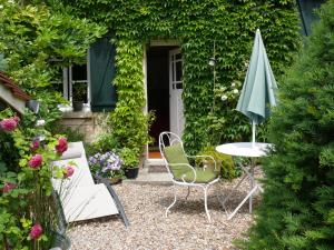 une terrasse avec une table et un parasol dans l'établissement A l'Ombre du Tilleul, à Giverny