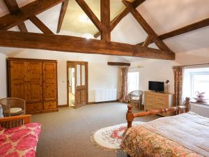 a bedroom with wooden ceilings and a bed and a tv at Maltkiln Court in Bickley