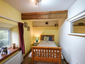 a small bedroom with a bed and a window at Maltkiln Court in Bickley