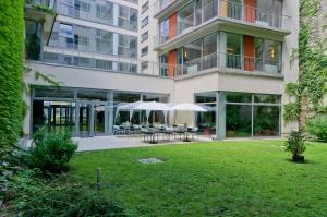 an apartment building with tables and umbrellas in a yard at Luxury Downtown Apartments in Budapest