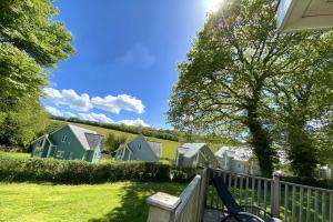 a row of houses with a bike parked next to a fence at Trewhiddle Retreat V25 by Together Travel - Luxury 4-Bedroom Villa in St Austell