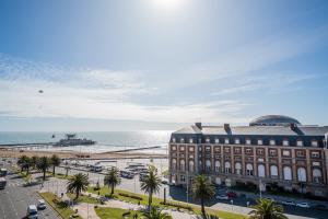 un grande edificio vicino all'oceano con palme di Hotel Riviera a Mar del Plata