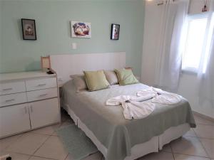 - une chambre avec un lit, une commode et une fenêtre dans l'établissement Pousada Irashai, à Juqueí