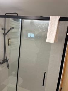 a glass shower door with a white towel on it at Casa da Linha in Amarante