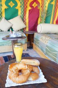 a table with a plate of bagels and a glass of orange juice at Araf House in Marrakesh
