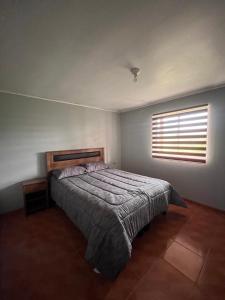 Schlafzimmer mit einem Bett und einem Fenster in der Unterkunft Casa de campo en Portezuelo 