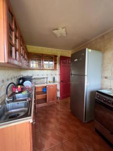 eine Küche mit einem Kühlschrank aus Edelstahl und einer Spüle in der Unterkunft Casa de campo en Portezuelo 