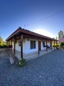 ein kleines weißes Haus mit einem Holzdach in der Unterkunft Casa de campo en Portezuelo 