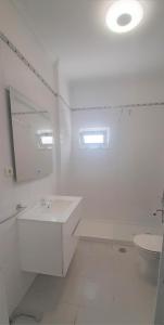 uma casa de banho branca com um lavatório e um WC em Jay Paradise - Paraíso Jota em Santa Cruz - Madeira