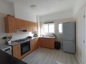 a kitchen with wooden cabinets and a white refrigerator at Jay Paradise - Paraíso Jota in Santa Cruz