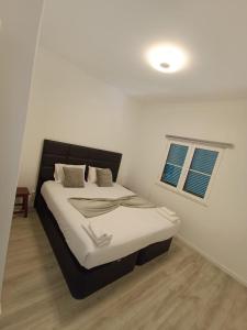 a bedroom with a bed with a black headboard and a window at Jay Paradise - Paraíso Jota in Santa Cruz