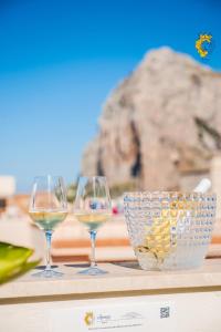 three wine glasses and a bowl on a table at Accussì rooms in San Vito lo Capo