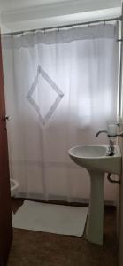 baño con lavabo y cortina de ducha en ALQUIFE, complejo de departamentos en Capilla del Monte