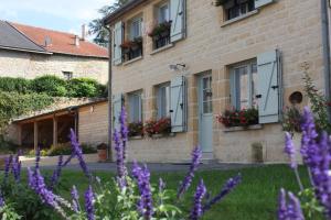 a building with purple flowers in front of it at Gîte LES ARMINAUX in Remilly-les-Pothées