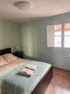 a bedroom with a bed with two towels on it at Casa del Bueno in Peralta de la Sal