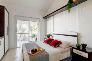 um quarto com uma cama grande e almofadas vermelhas em Embaúba House Casa de Praia, Praia Particular. em Florianópolis