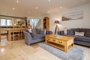 a living room with a couch and a table at Trewhiddle Retreat V24 by Together Travel - Luxury 4-Bedroom Villa in St Austell