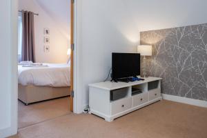 a bedroom with a bed and a tv on a dresser at Trewhiddle Retreat V24 by Together Travel - Luxury 4-Bedroom Villa in St Austell
