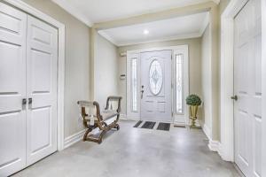 a hallway with a chair in front of a door at 5 Bedroom Vacation Cottage - King City in Schomberg