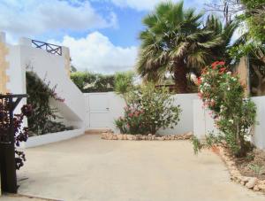 a driveway leading to a white house with flowers at Casa Del Medio in Antigua +72 photos