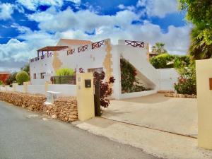 a white house with a fence and a street at Casa Del Medio in Antigua