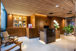 メデジンにあるElcielo Hotel Luxury Medellinの木製の壁のオフィス、デスク、椅子