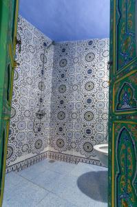 La salle de bains est pourvue d'une douche et d'un mur en carrelage. dans l'établissement Dar El Fanne, à Chefchaouen