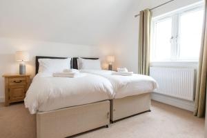 Un dormitorio con una gran cama blanca y una ventana en Trewhiddle Villa 18 en St Austell