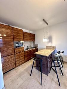 a kitchen with wooden cabinets and a counter with stools at Krawiecka 3 - City Center - 7 People - Private Parking in Wrocław
