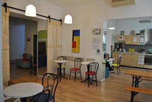 a room with tables and chairs and a kitchen at Balarm Hostel - Youth Hostel age limit 18-50 in Palermo