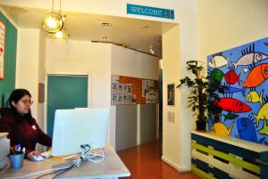 a woman sitting at a desk with a computer at Balarm Hostel - Youth Hostel age limit 18-50 in Palermo